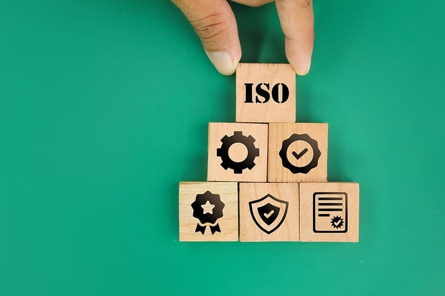 wooden blocks with certification icons on them on a green background