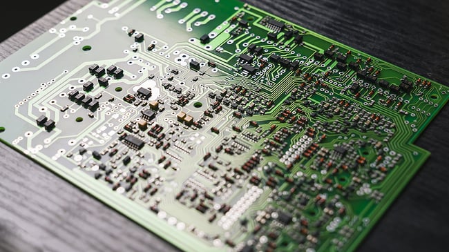 printed circuit board laying on a black wooden table