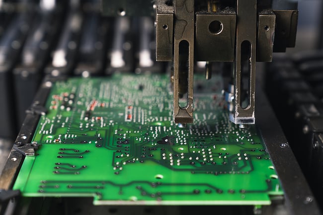 Close up photo of an electronic manufacturing machine working on a printed circuit board