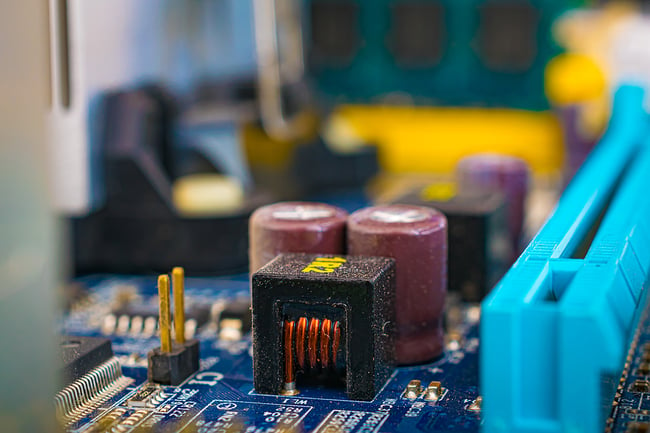 close up photo of a blue printed circuit board with electronic components 