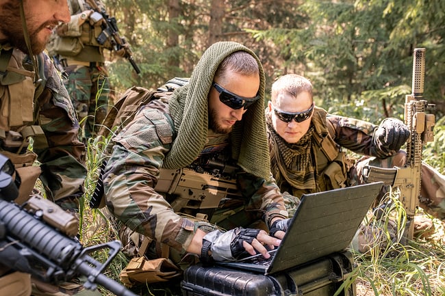 military members using electronics in the field.