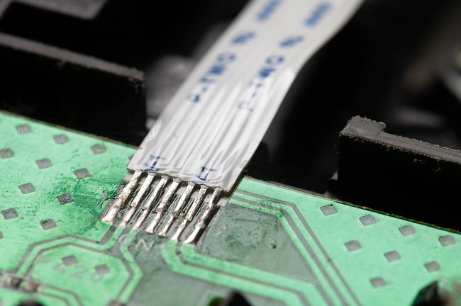 Close up photo of a flexible circuit attached to a printed circuit board.