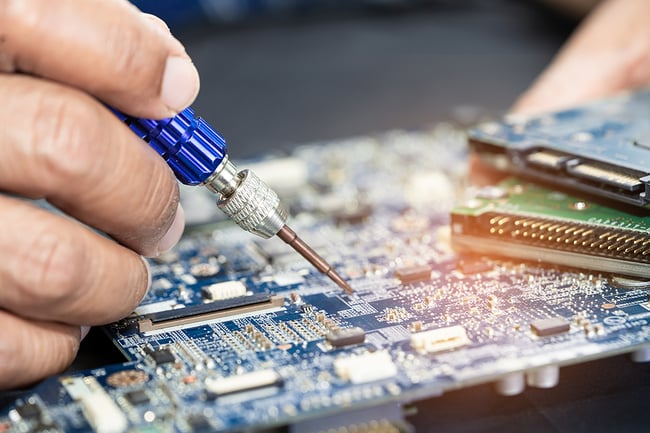 Technician soldering on a printed circuit board.